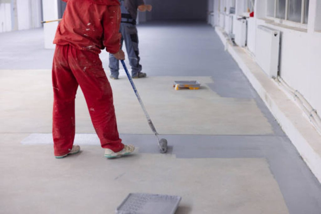 painter applies heavy traffic gray resin in the factory